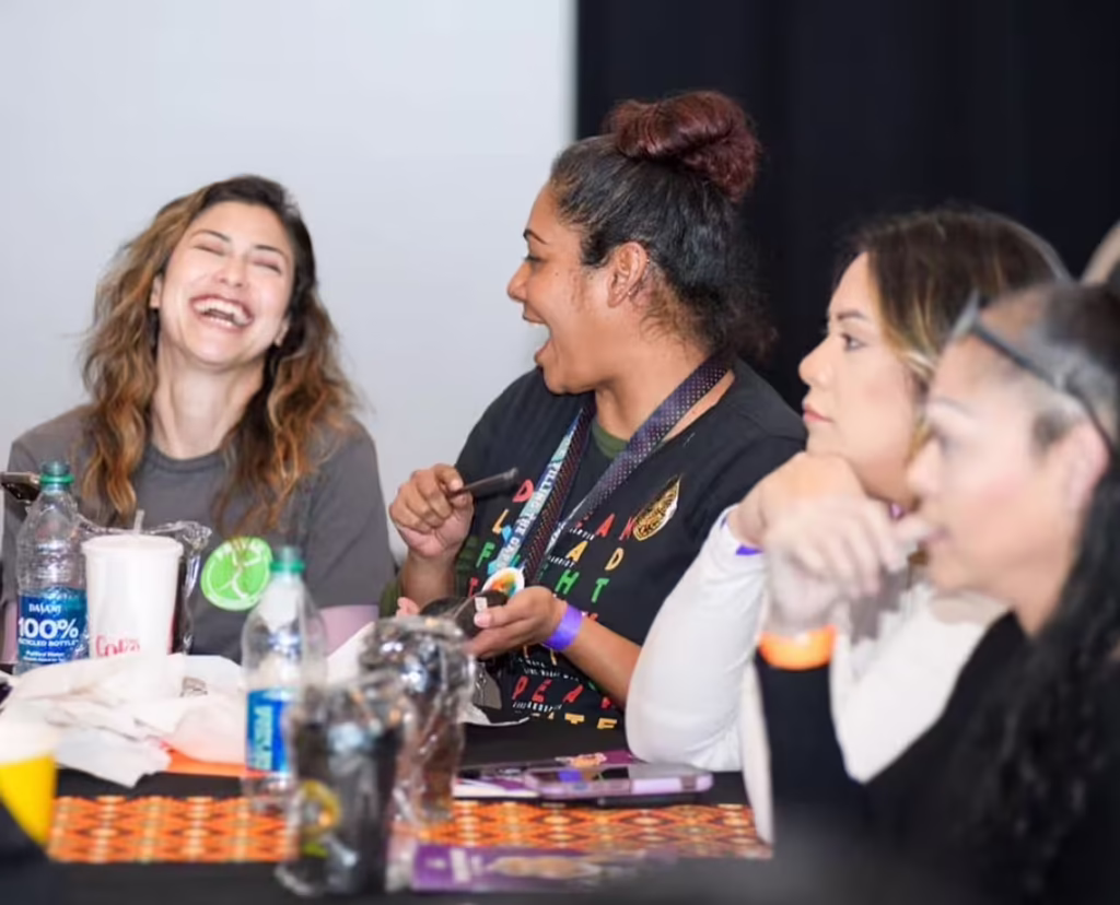San Joaquin Pride Center staff members talking and laughing together at a community event.